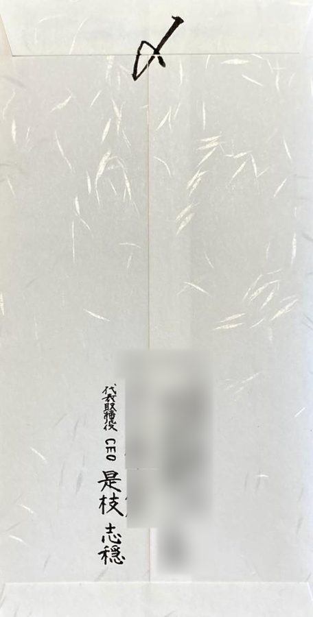 封筒の裏面。差出人の役職と氏名を手書きしています